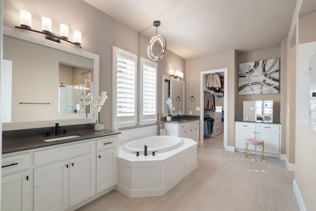 bathroom featuring a spacious closet, two vanities, a sink, and tile patterned floors