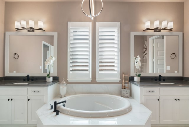 bathroom featuring a sink, two vanities, and a bath