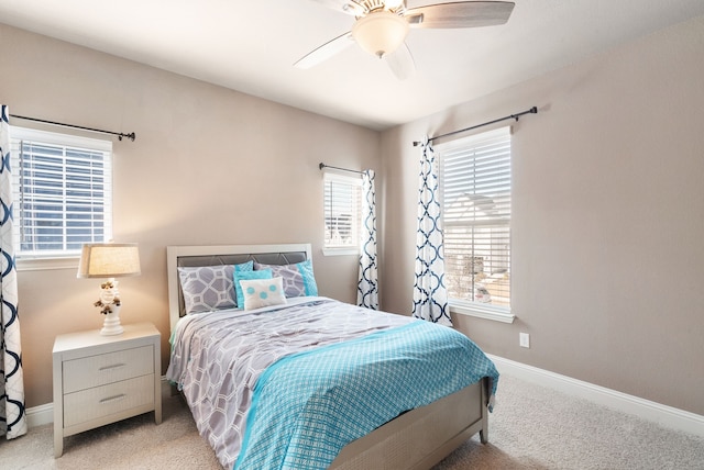 bedroom featuring ceiling fan, baseboards, and light colored carpet