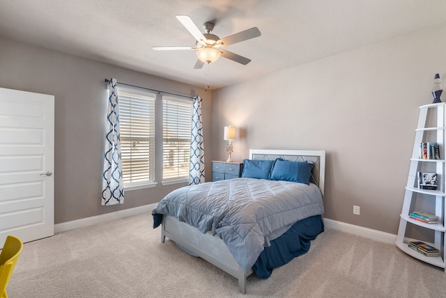 bedroom with a ceiling fan, light colored carpet, and baseboards