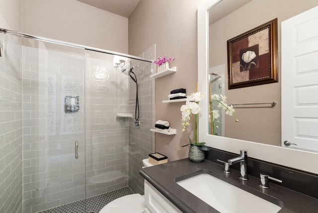 bathroom featuring toilet, a stall shower, and vanity