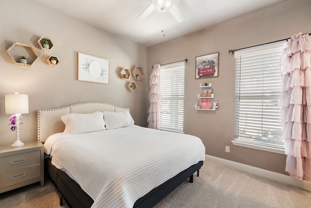 bedroom with light carpet, baseboards, and a ceiling fan