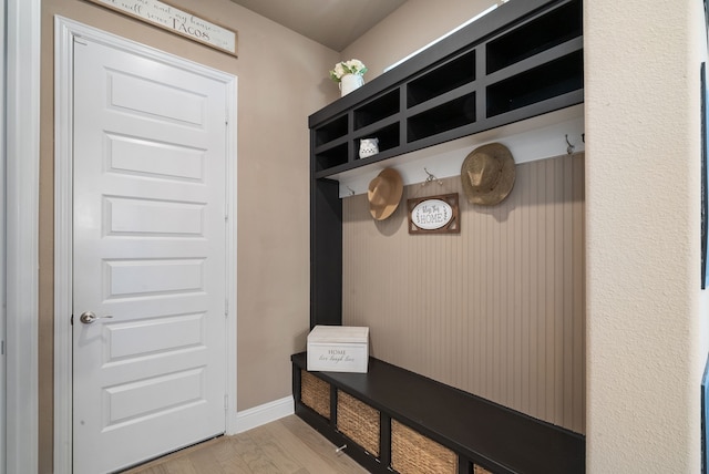 mudroom featuring light wood-style flooring and baseboards