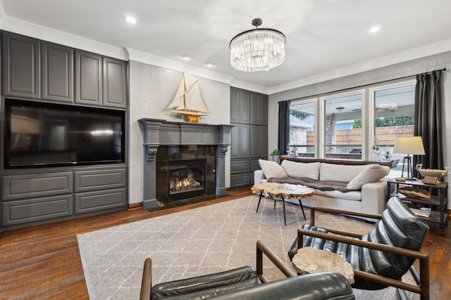 living room featuring dark hardwood / wood-style floors, ornamental molding, a premium fireplace, and a chandelier