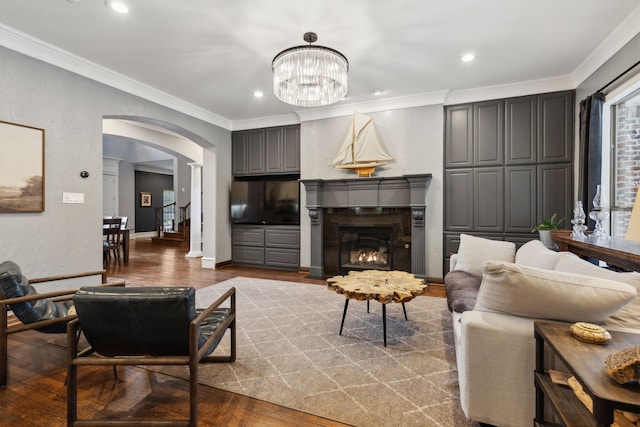 living room featuring a notable chandelier, crown molding, and wood-type flooring