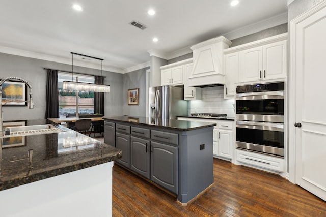 kitchen featuring gray cabinetry, white cabinets, custom exhaust hood, ornamental molding, and stainless steel appliances