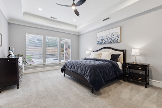 carpeted bedroom featuring crown molding, ceiling fan, and a raised ceiling