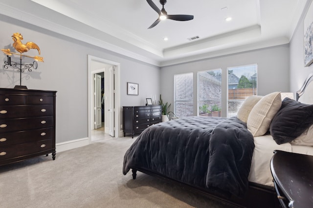 bedroom with a raised ceiling, crown molding, light colored carpet, and ceiling fan