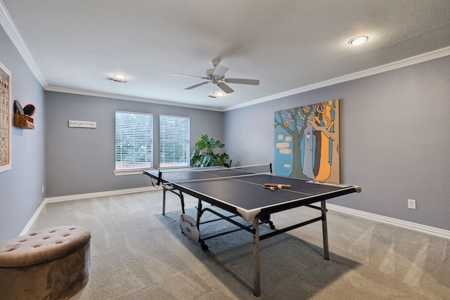 rec room with ornamental molding, ceiling fan, and carpet