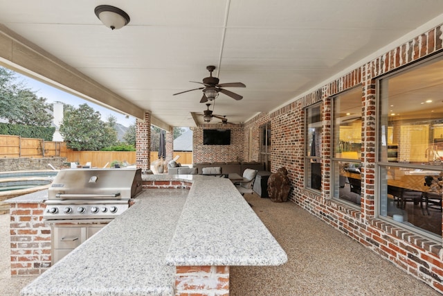 view of patio / terrace with ceiling fan, area for grilling, and a grill