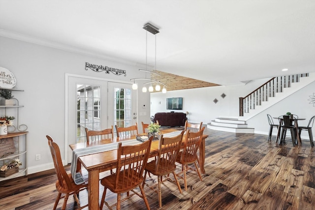 dining room with wood-type flooring, ornamental molding, an inviting chandelier, and french doors