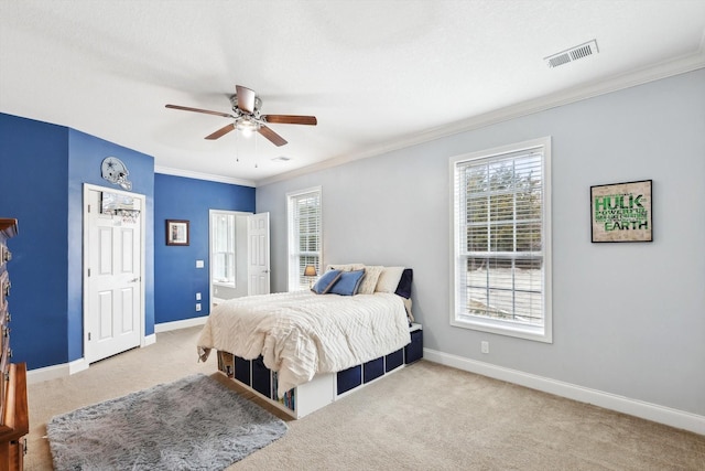 carpeted bedroom featuring multiple windows, ornamental molding, and ceiling fan