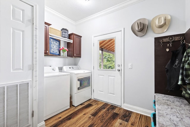 clothes washing area featuring cabinets, crown molding, dark hardwood / wood-style floors, and washer and clothes dryer