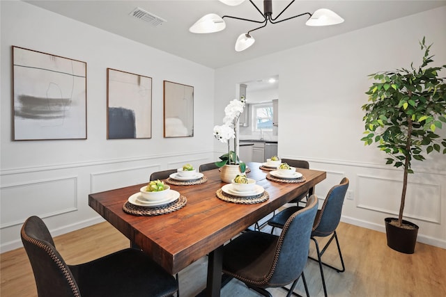 dining space with an inviting chandelier and light hardwood / wood-style floors