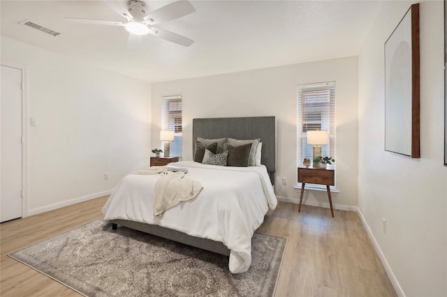 bedroom with ceiling fan, multiple windows, and light wood-type flooring