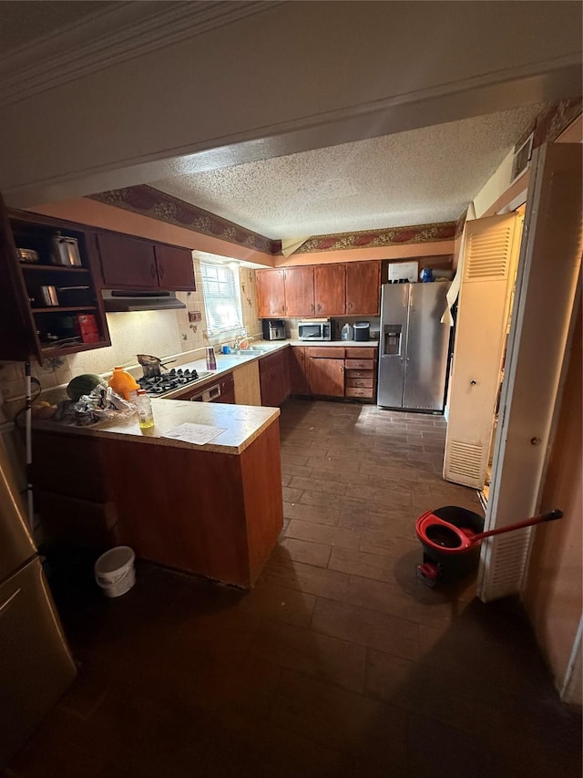 kitchen featuring appliances with stainless steel finishes, a textured ceiling, ornamental molding, sink, and kitchen peninsula