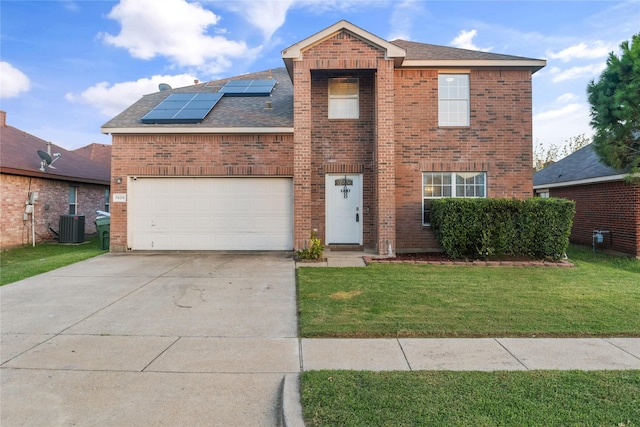 view of front of property with central AC, a front yard, and solar panels