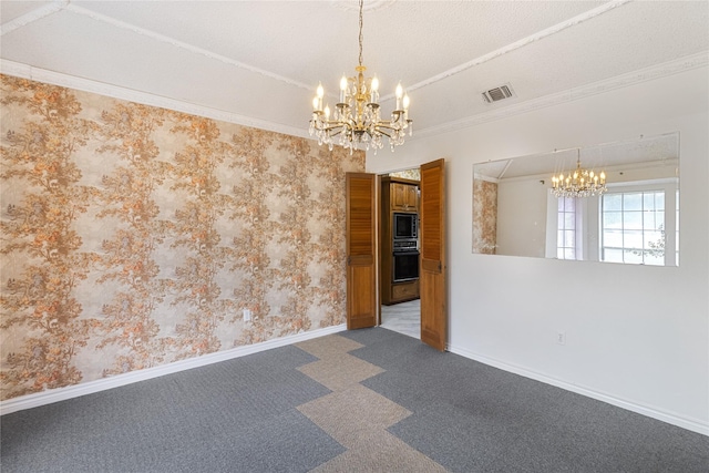 empty room with ornamental molding, a chandelier, and carpet floors