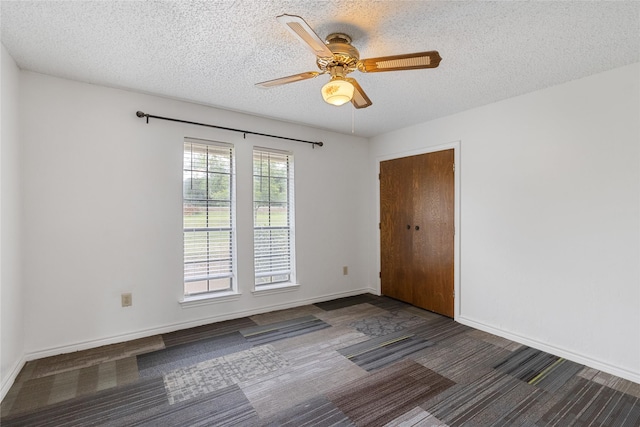 spare room with ceiling fan, carpet floors, and a textured ceiling