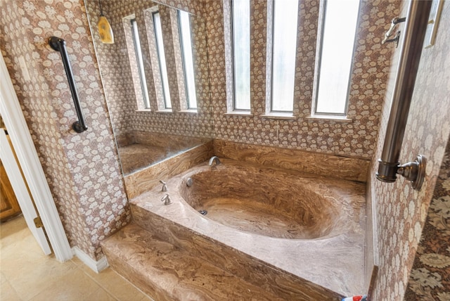 bathroom with a healthy amount of sunlight, tile patterned flooring, and tiled tub