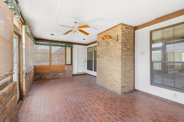 unfurnished sunroom with ceiling fan