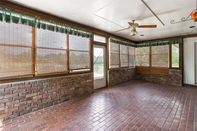 unfurnished sunroom featuring ceiling fan