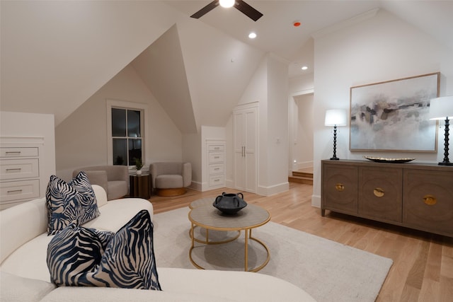 living room featuring ceiling fan, vaulted ceiling, and light hardwood / wood-style flooring