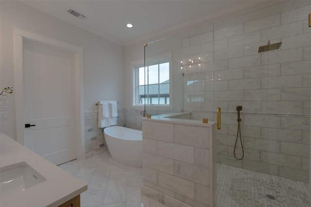 bathroom with crown molding, separate shower and tub, tile walls, and vanity