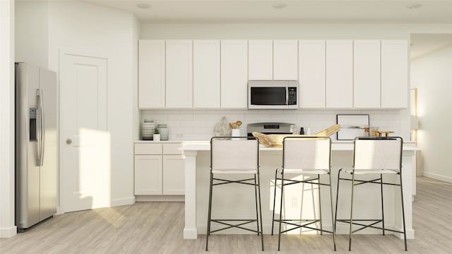 kitchen with stainless steel fridge with ice dispenser, a breakfast bar, white cabinets, and light wood-type flooring