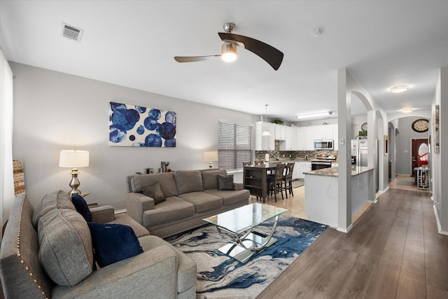 living room with ceiling fan and light hardwood / wood-style floors