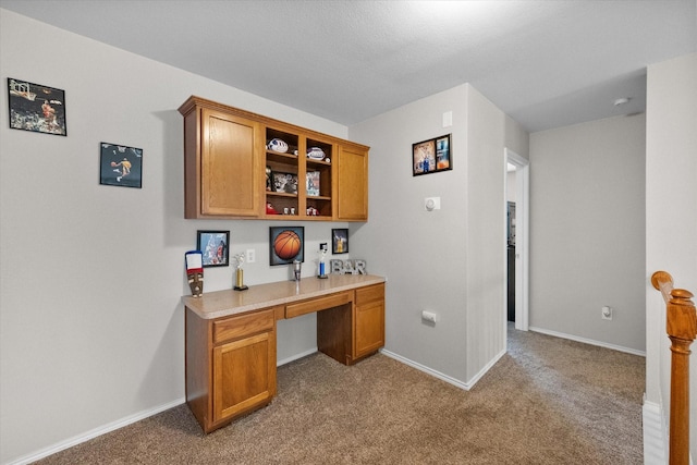 carpeted home office featuring built in desk