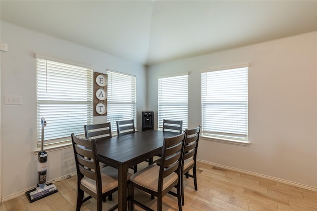 dining area featuring plenty of natural light, lofted ceiling, and light hardwood / wood-style flooring