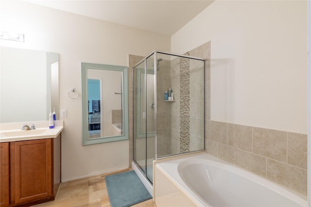 bathroom featuring vanity, hardwood / wood-style flooring, and plus walk in shower