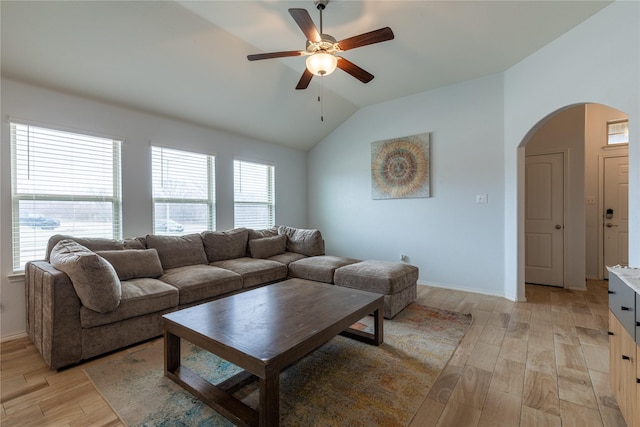 living room featuring ceiling fan, lofted ceiling, and light wood-type flooring