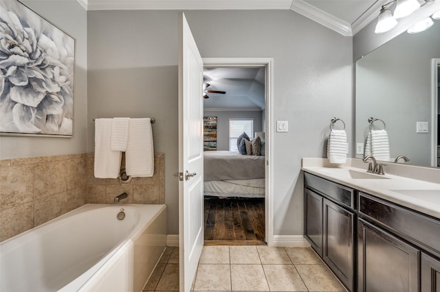 bathroom with tile patterned floors, ornamental molding, vanity, a tub, and ceiling fan