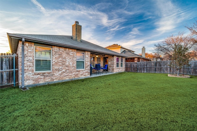 rear view of property with a patio and a lawn