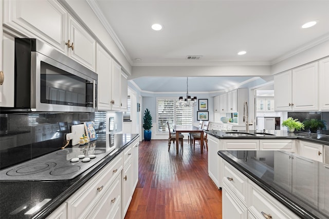 kitchen featuring sink, black electric cooktop, dark hardwood / wood-style flooring, pendant lighting, and white cabinets