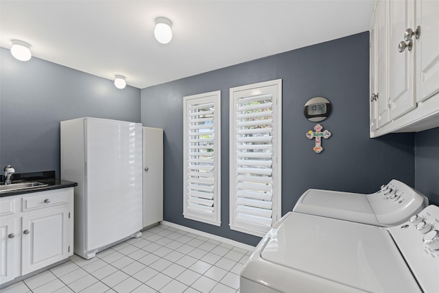 clothes washing area with cabinets, washing machine and dryer, sink, and light tile patterned flooring