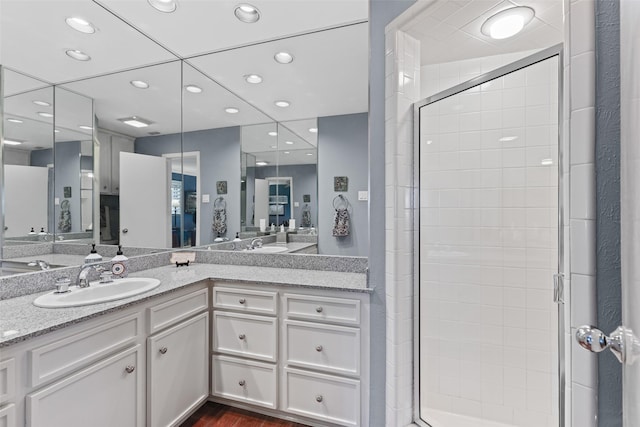 bathroom featuring vanity, hardwood / wood-style floors, and a shower with shower door