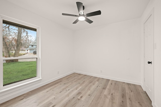 empty room with ceiling fan and light hardwood / wood-style flooring