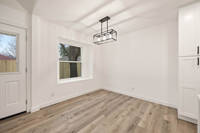 unfurnished dining area featuring light wood-type flooring