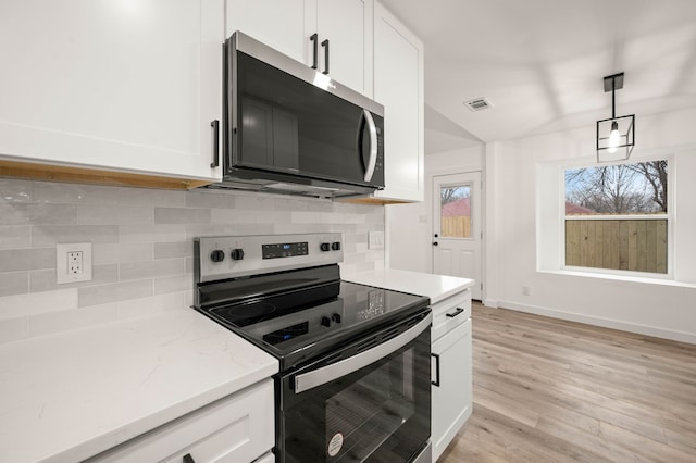 kitchen featuring hanging light fixtures, white cabinets, and appliances with stainless steel finishes