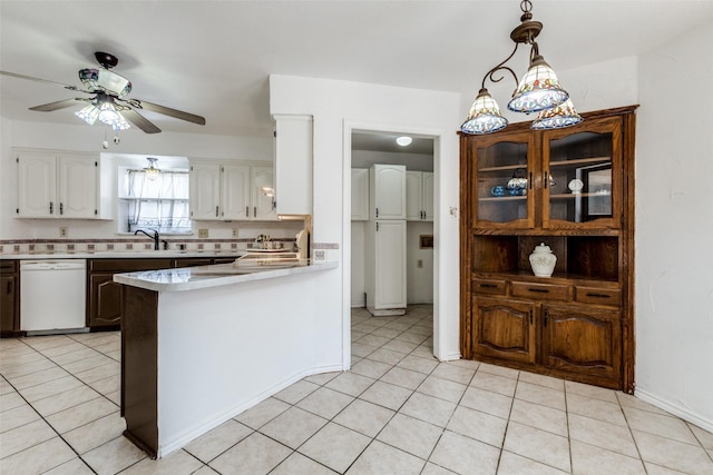 kitchen featuring decorative light fixtures, white cabinetry, sink, light tile patterned floors, and white dishwasher