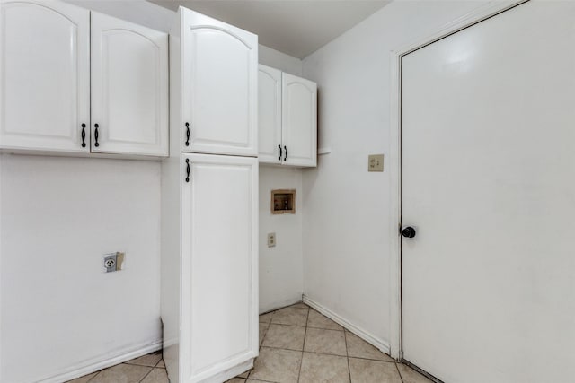 laundry room with light tile patterned flooring, cabinets, and hookup for an electric dryer