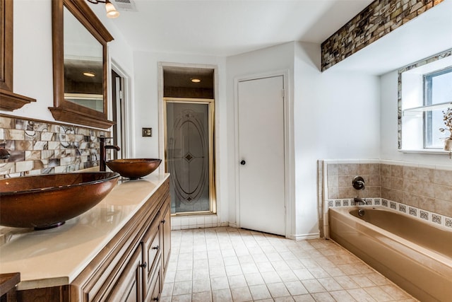 bathroom featuring tile patterned flooring, vanity, separate shower and tub, and decorative backsplash