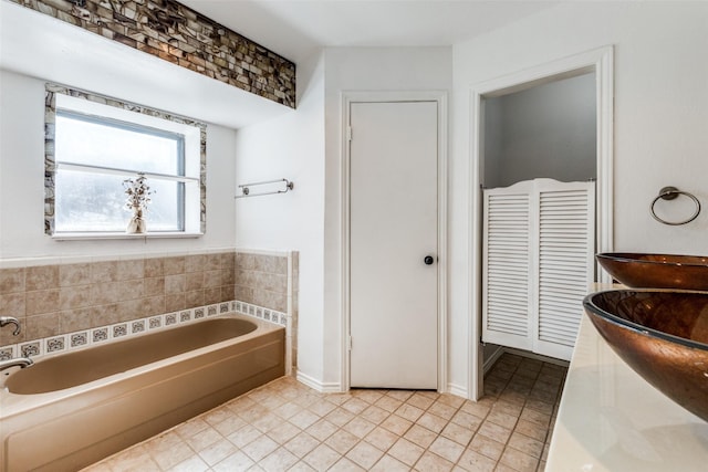 bathroom with vanity, a tub to relax in, and tile patterned flooring