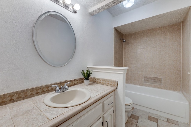 full bathroom featuring tiled shower / bath combo, vanity, a textured ceiling, and toilet