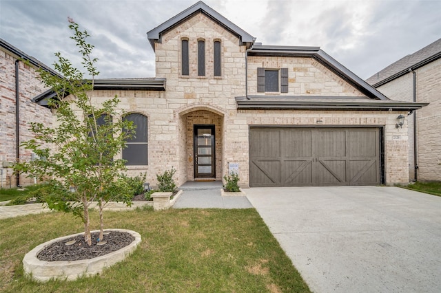 french country home featuring a garage and a front lawn