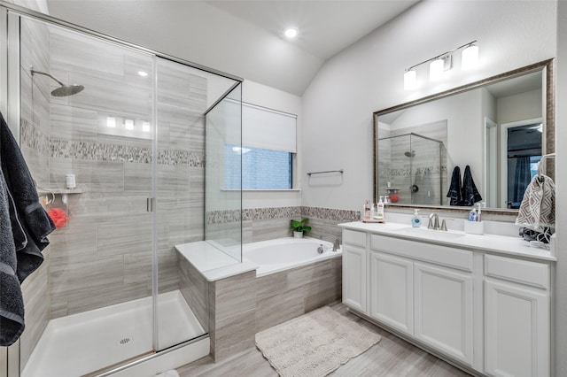 bathroom with vanity, separate shower and tub, and vaulted ceiling