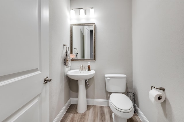 bathroom featuring hardwood / wood-style floors and toilet